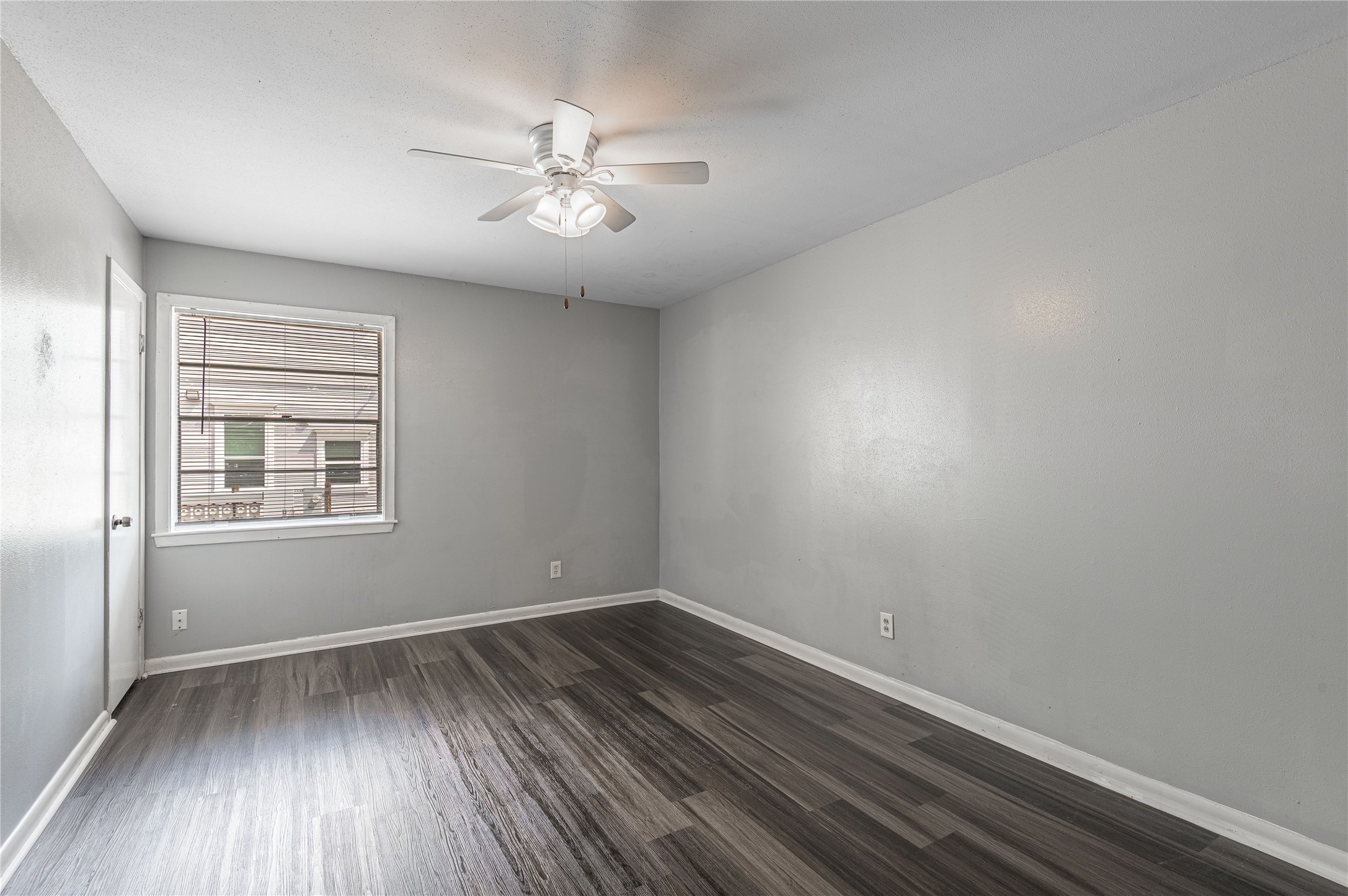 818 University Avenue, Unit 8 Huntsville, TX 77320 - Photo 10 of 22 wooden floor in an empty room with a window