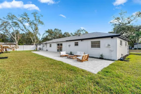 a view of a house with backyard and sitting area