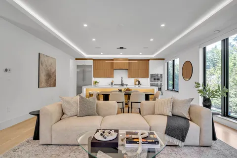 a living room with furniture kitchen and a large window