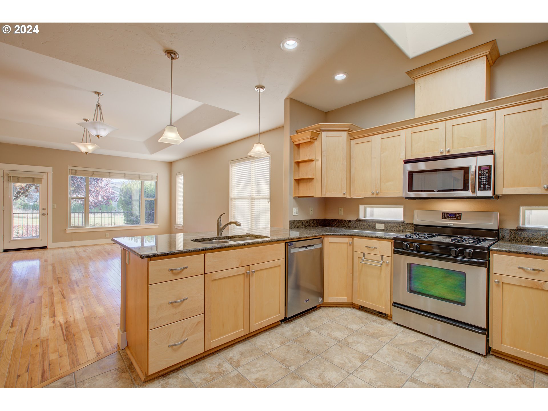 436 Backwater Loop Sutherlin, OR 97479 - Photo 13 of 46 a kitchen with stainless steel appliances granite countertop a stove top oven a sink dishwasher and a refrigerator with wooden floor