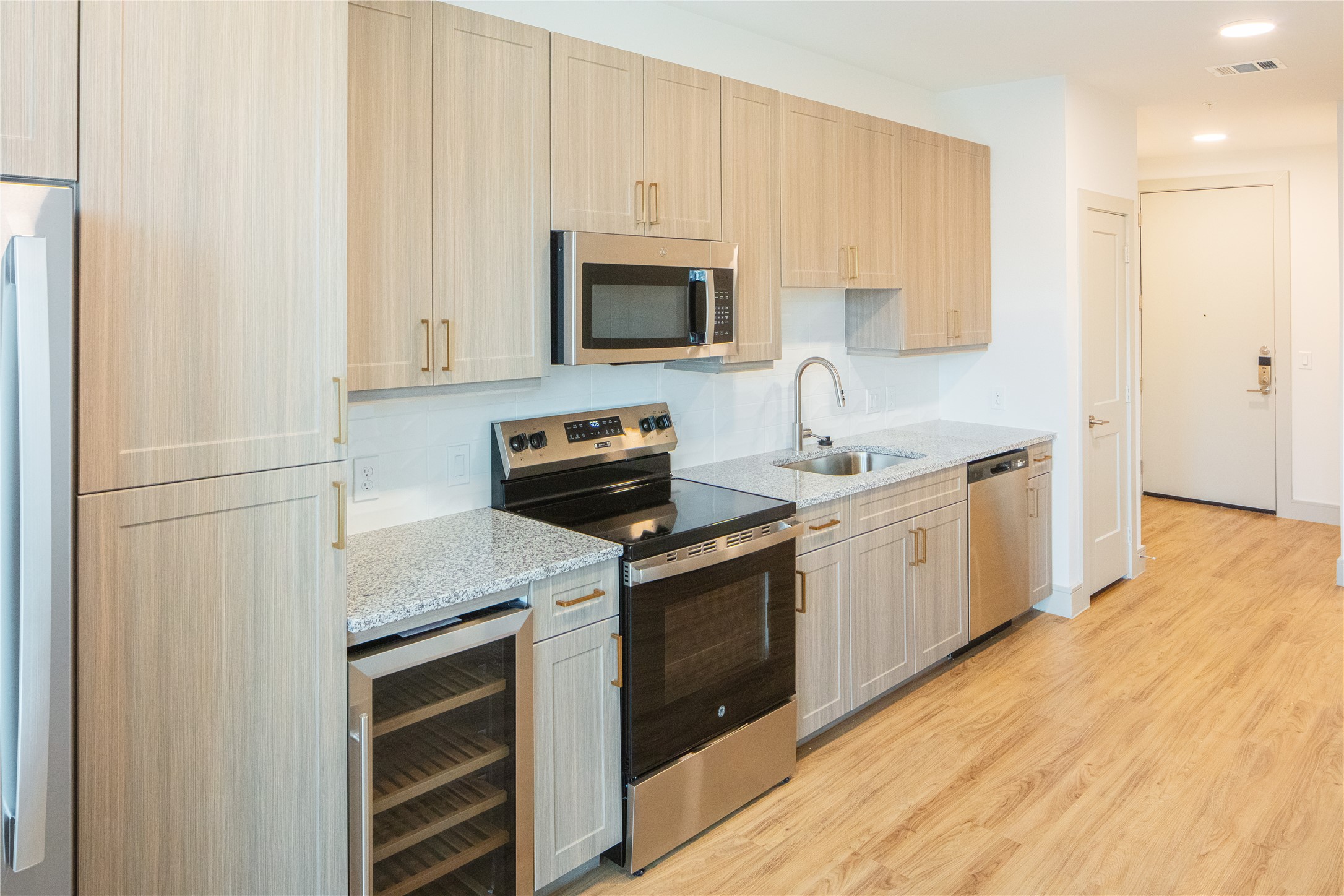 3100 Scofield Ridge Parkway, Unit 1422 Austin, TX 78727 - Photo 8 of 21 Kitchen featuring light wood finished floors, beverage cooler, visible vents, appliances with stainless steel finishes, and a sink