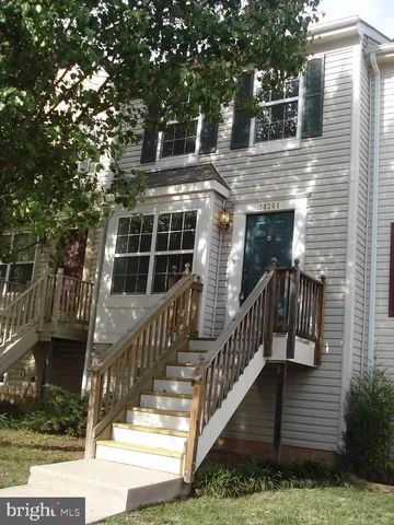 a view of house with a yard and potted plants