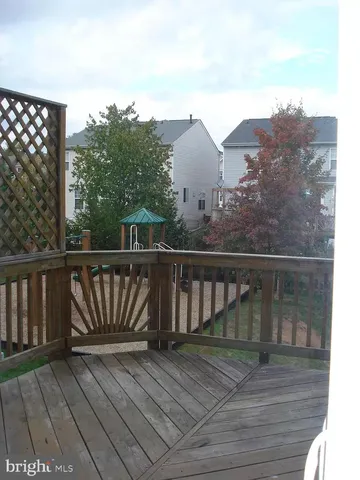 a view of a balcony with wooden floor and fence