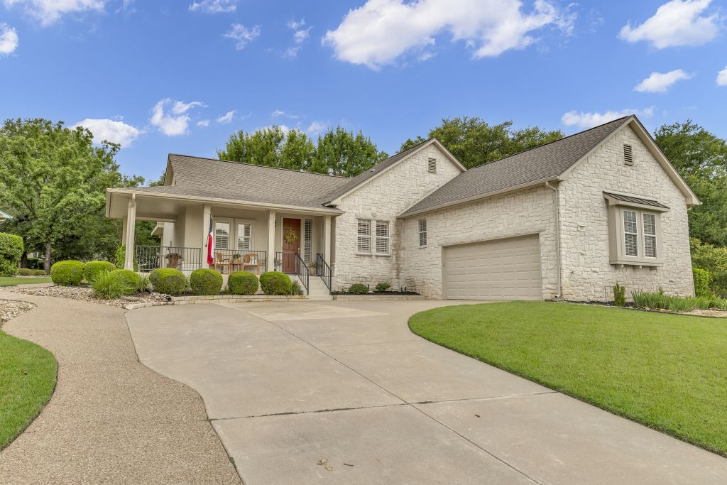 144 Cattle Trail Way Georgetown, TX 78633 - Photo 29 of 37 A graceful home featuring light-toned brickwork and an inviting covered front porch, complemented by a long, curving driveway.