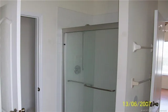 an empty room with a fan & a window