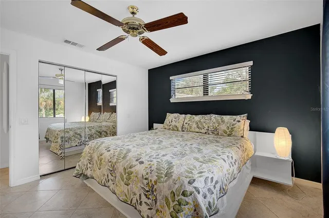 a bedroom with a bed and a large mirror