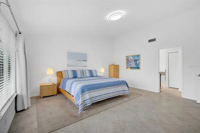 a spacious bedroom with a bed and a cabinets