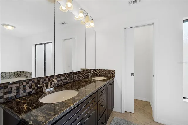 a bathroom with a granite countertop sink and a mirror