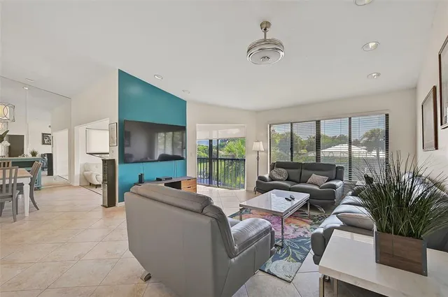 a living room with furniture large window and flat screen tv