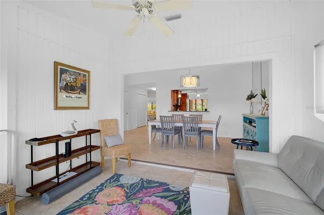 a living room with furniture and a dining table with garden view