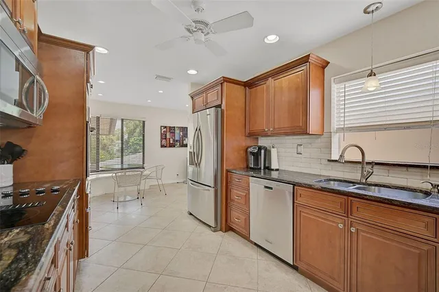 a kitchen with stainless steel appliances granite countertop a sink stove and refrigerator
