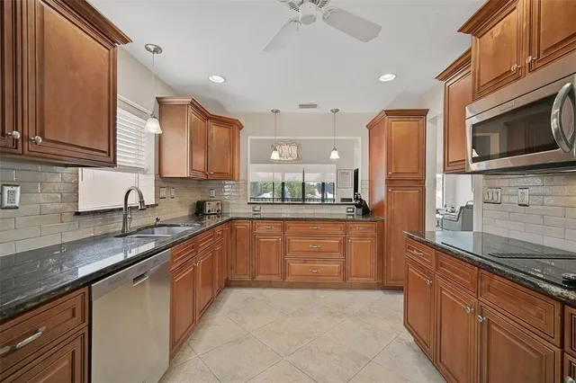 a large kitchen with stainless steel appliances granite countertop a sink stove and refrigerator