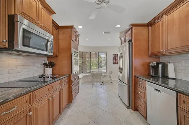 a kitchen with stainless steel appliances granite countertop a refrigerator and a sink