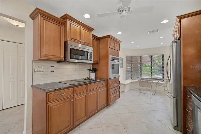 a kitchen with stainless steel appliances granite countertop a refrigerator and a stove top oven