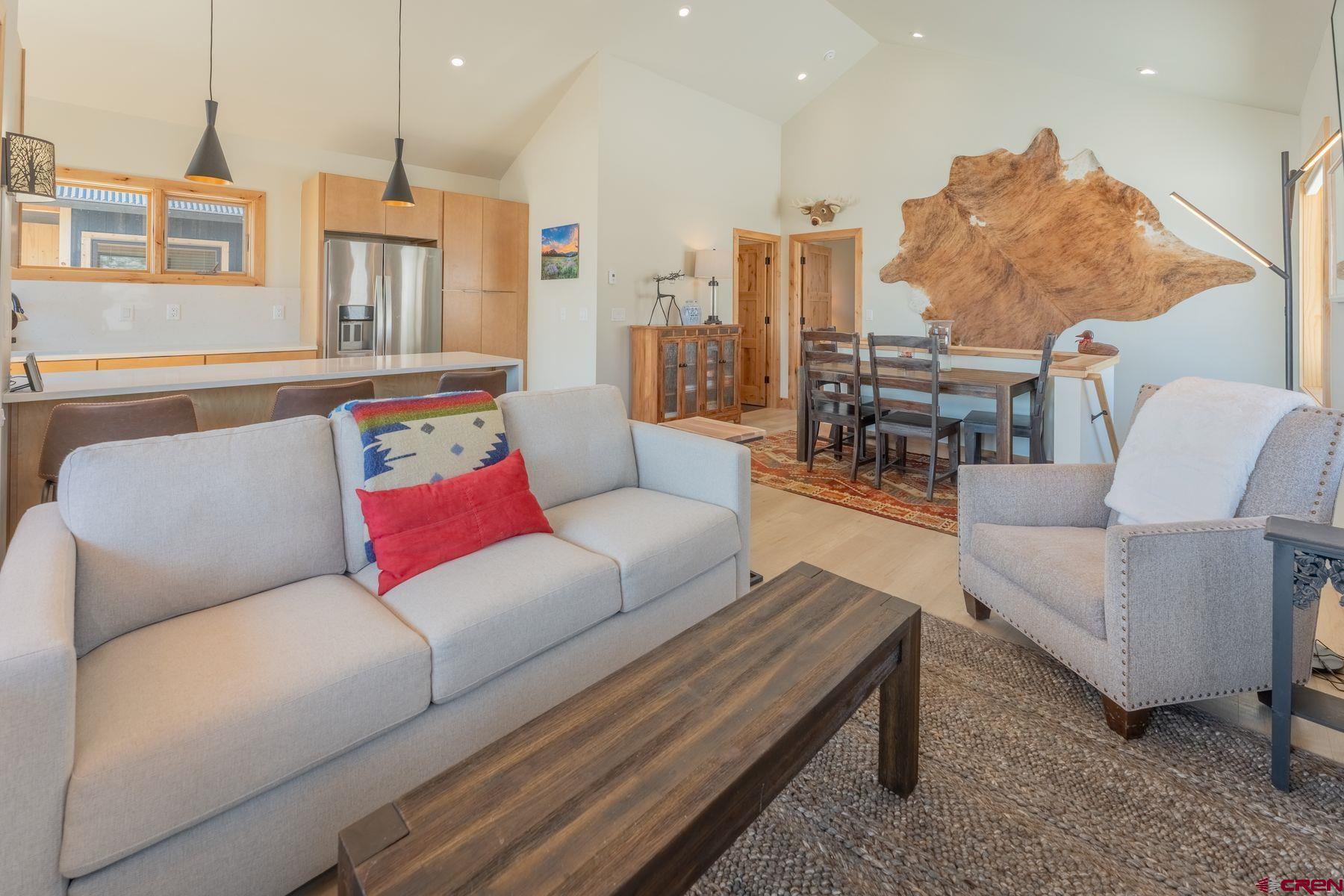 231 Elk Valley Road, Unit 2D Crested Butte, CO 81224 - Photo 14 of 35 a living room with furniture kitchen view and a chandelier