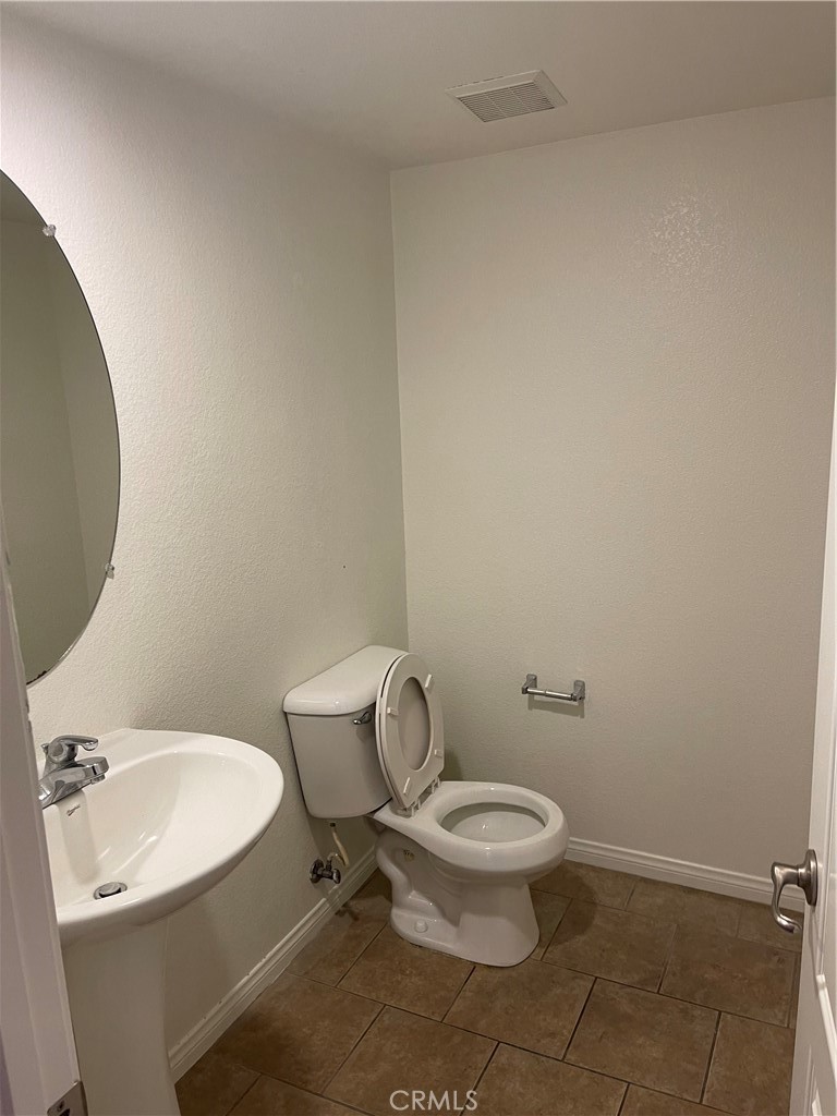 4438 Leonard Court Riverside, CA 92501 - Photo 13 of 36 a white toilet sitting next to a bathroom sink