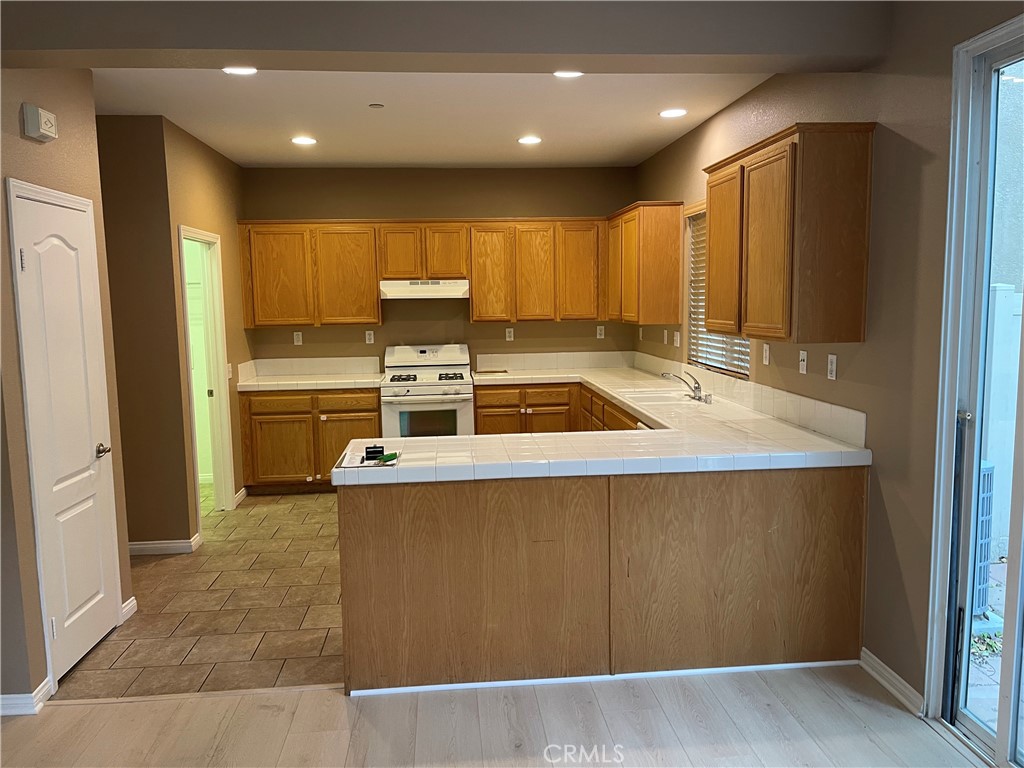 4438 Leonard Court Riverside, CA 92501 - Photo 7 of 36 a kitchen with kitchen island a sink a stove a refrigerator cabinets and a window