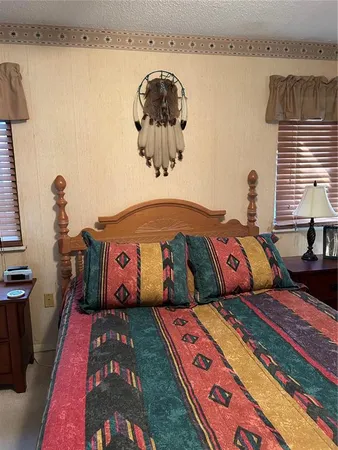 a bedroom with a bed and a lamp on dresser