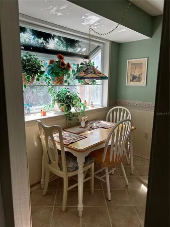 a patio with table and chairs and potted plants