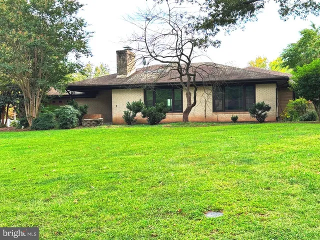 a view of a house with a yard and sitting area
