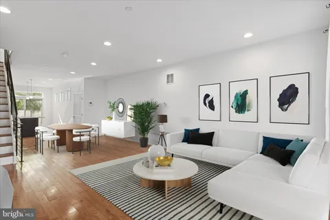 a living room with furniture and a dining table with wooden floor