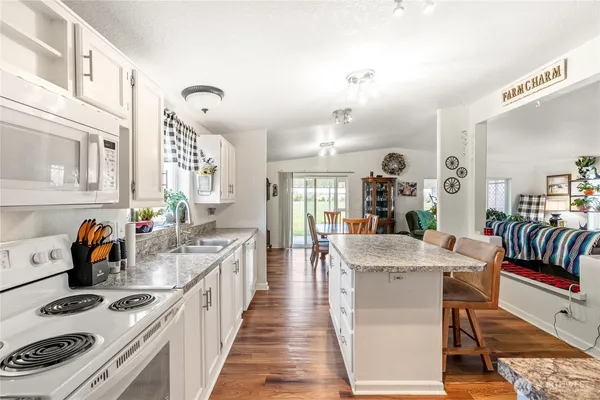 a kitchen with granite countertop a sink and refrigerator