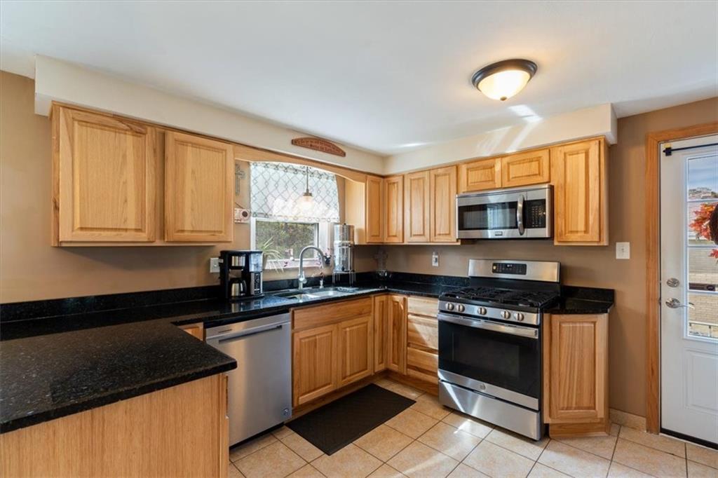 12490 Adams Drive Irwin, PA 15642 - Photo 7 of 33 a kitchen with stainless steel appliances granite countertop a stove a sink and a microwave