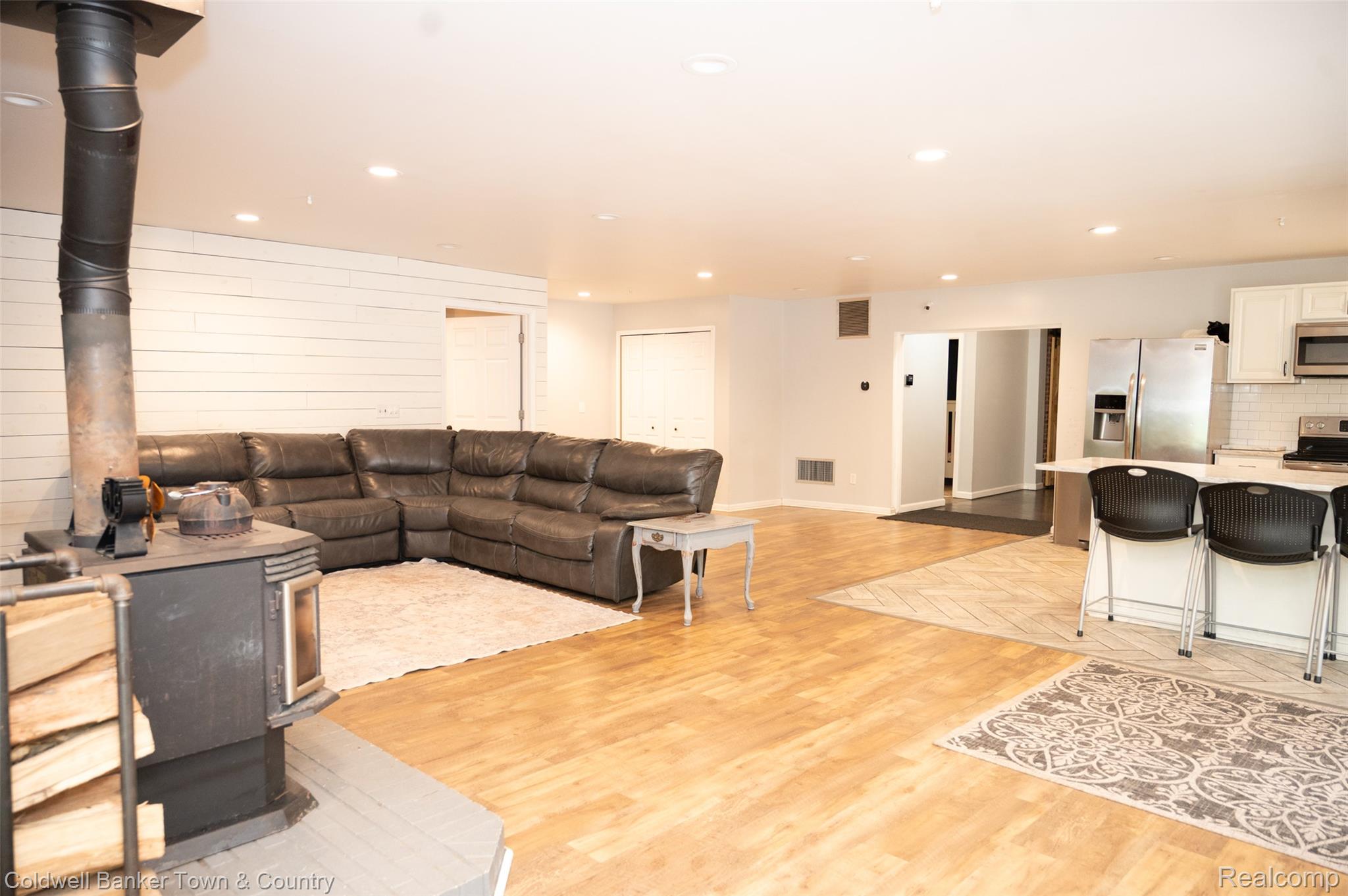 6150 North Fleming Road Howell, MI 48855 - Photo 7 of 23 Open concept living space featuring wood-finish flooring, recessed lighting, and a prominent wood-burning stove