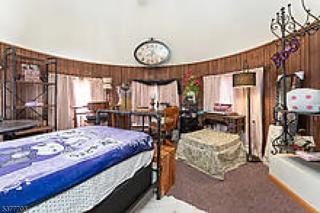 a bedroom with a bed a large window and walk in closet