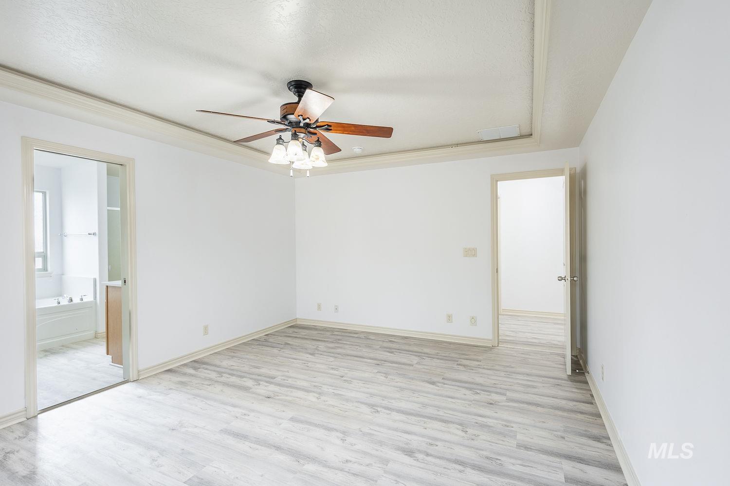 4227 North Rhodes Avenue Meridian, ID 83646 - Photo 9 of 27 Spacious room featuring wood-finish flooring, a tray ceiling, and a ceiling fan with integrated lighting