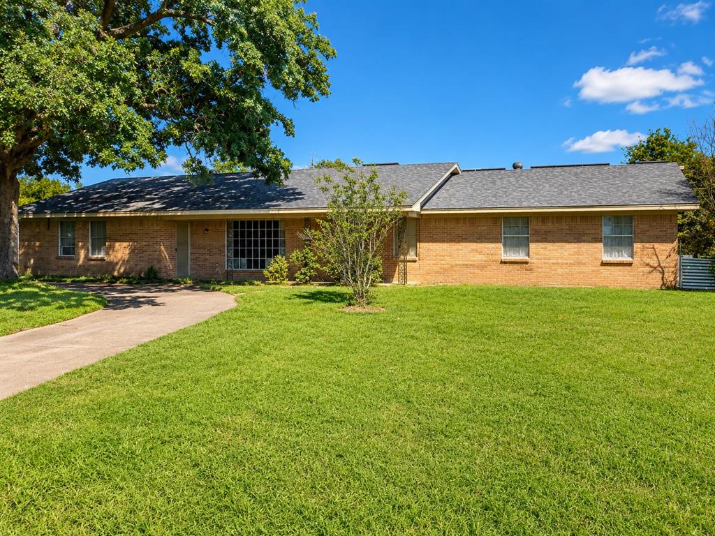1081 Wright Street Terrell, TX 75160 - Photo 2 of 29 Brick exterior residence featuring a curved driveway, mature tree, and expansive front lawn