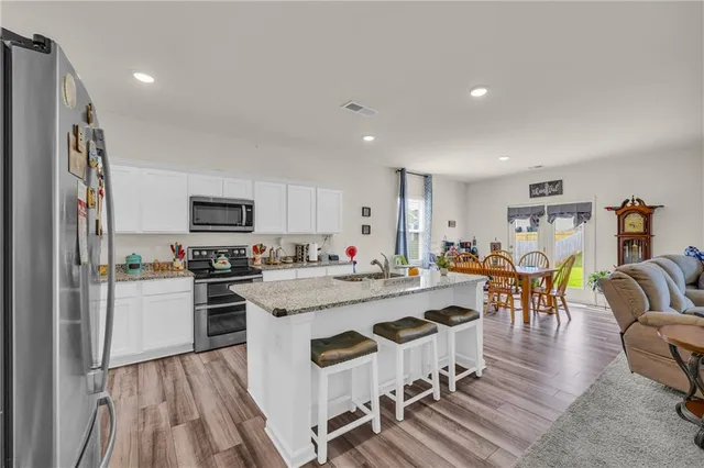 a kitchen with stainless steel appliances granite countertop a refrigerator and a stove top oven