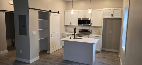 a kitchen with stainless steel appliances a refrigerator and a stove top oven