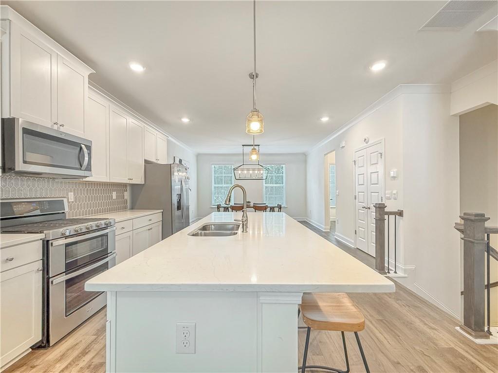 1160 Kendron Lane, Unit 16 Atlanta, GA 30329 - Photo 4 of 39 a large kitchen with kitchen island a stove a sink a refrigerator and cabinets