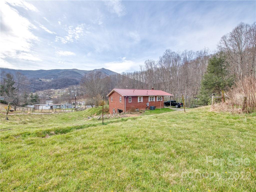 208 Balsam Ridge Road Waynesville, NC 28786 - Photo 4 of 25 a view of a house with a big yard potted plants and large trees