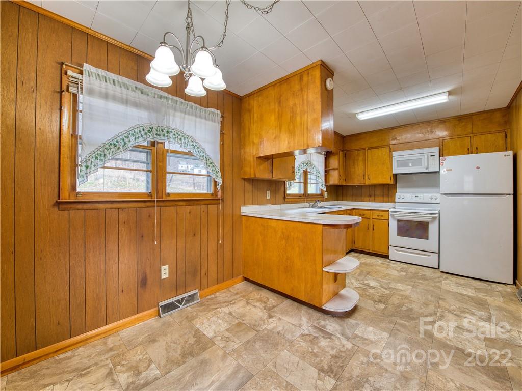 208 Balsam Ridge Road Waynesville, NC 28786 - Photo 9 of 25 a kitchen with a refrigerator a stove cabinets and living room view