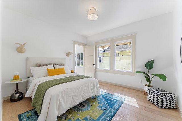 a bedroom with a bed dresser and a window