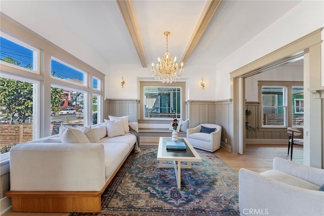a living room with furniture a chandelier and a large window