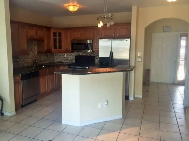 a kitchen with stainless steel appliances granite countertop a stove a sink and a microwave