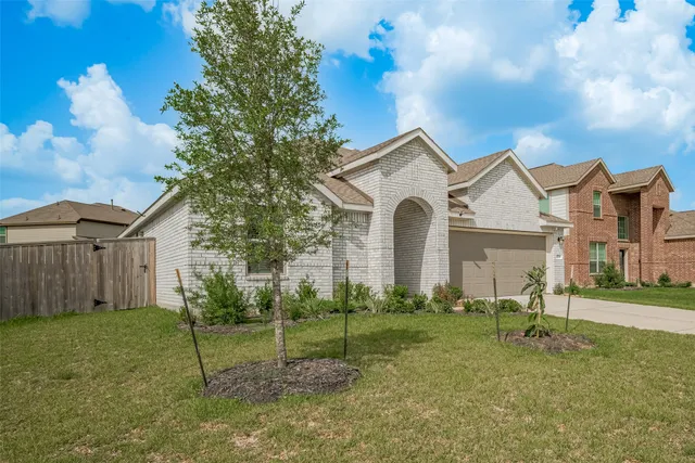 a view of a white house with a yard and plants