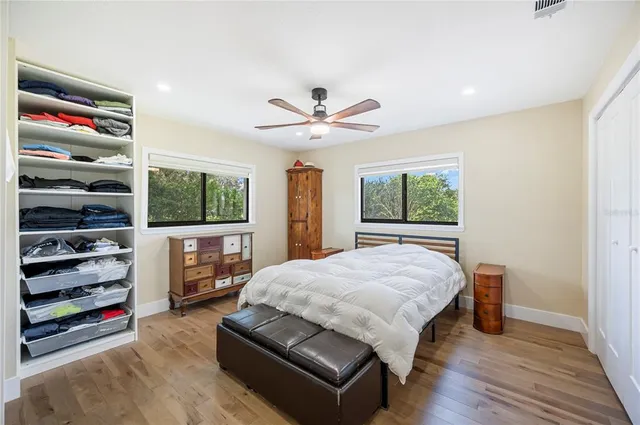 a bedroom with a bed and a ceiling fan