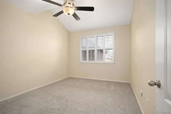 an empty room with closet and a chandelier fan