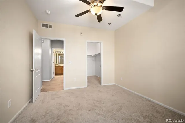 an empty room with a window and a fan