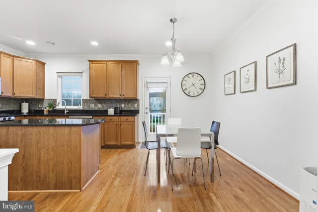 a kitchen with granite countertop stainless steel appliances a refrigerator a stove top oven cabinets a sink and a window