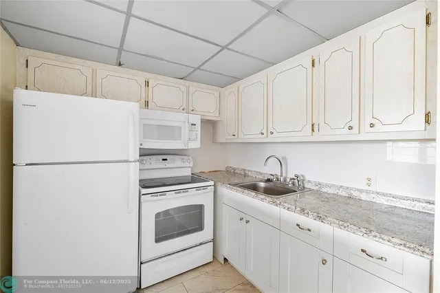a white refrigerator freezer sitting inside of a kitchen