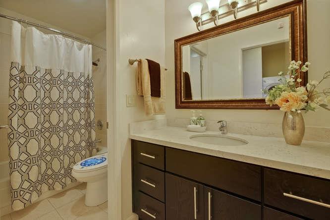 100 East Middlefield Road, Unit 2B Mountain View, CA 94043 - Photo 21 of 28 a bathroom with a granite countertop sink toilet a mirror and shower curtain