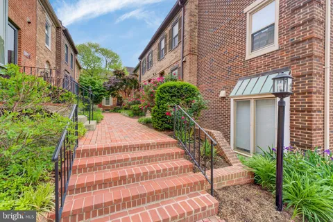 a view of a brick house with a yard and plants