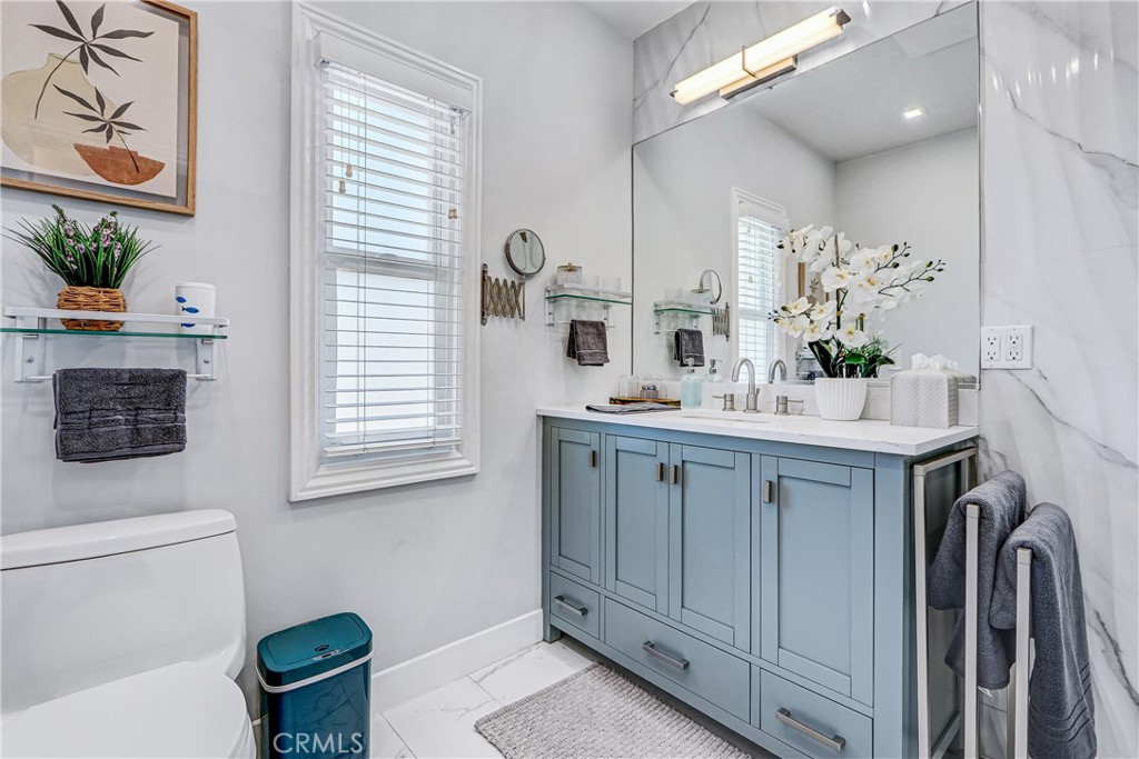 230 40th Street, Unit 1 Manhattan Beach, CA 90266 - Photo 14 of 19 a bathroom with a sink a toilet and a mirror