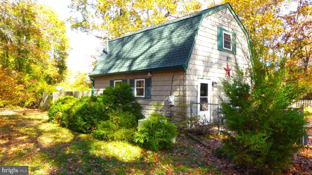 a yellow house with flower garden in front of it