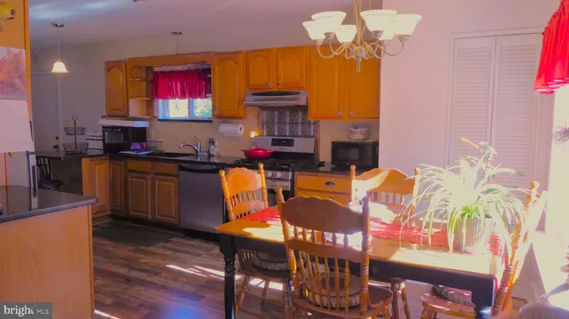 a view of a dining room with furniture a chandelier and wooden floor